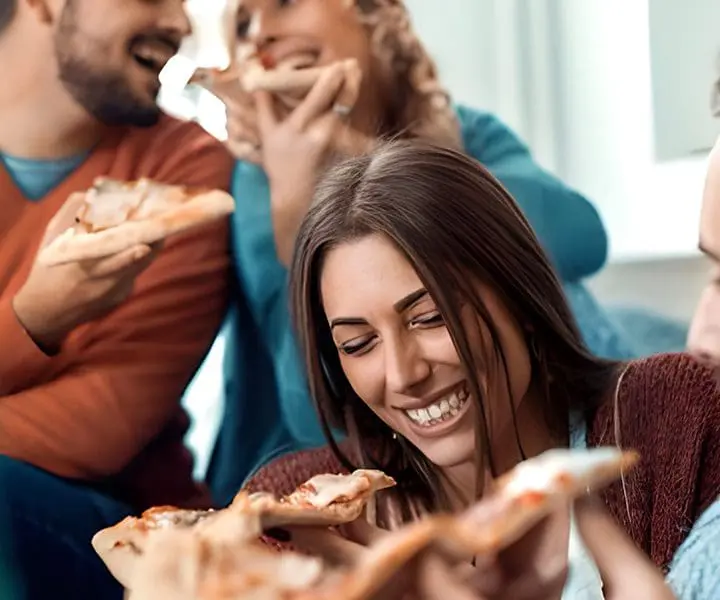 A group of people eating pizza together.