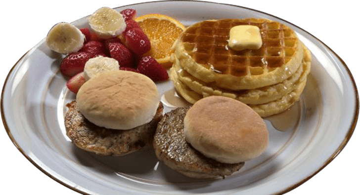 A plate of food with biscuits, fruit and waffles.
