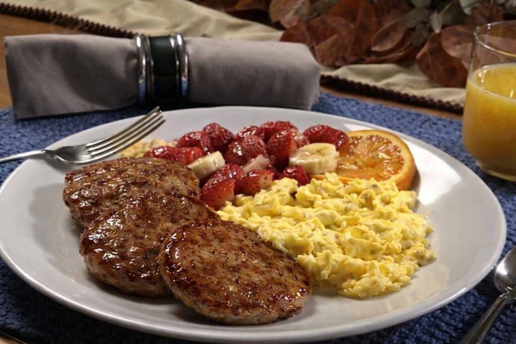Plate with scrambled eggs, sausage, and fruit
